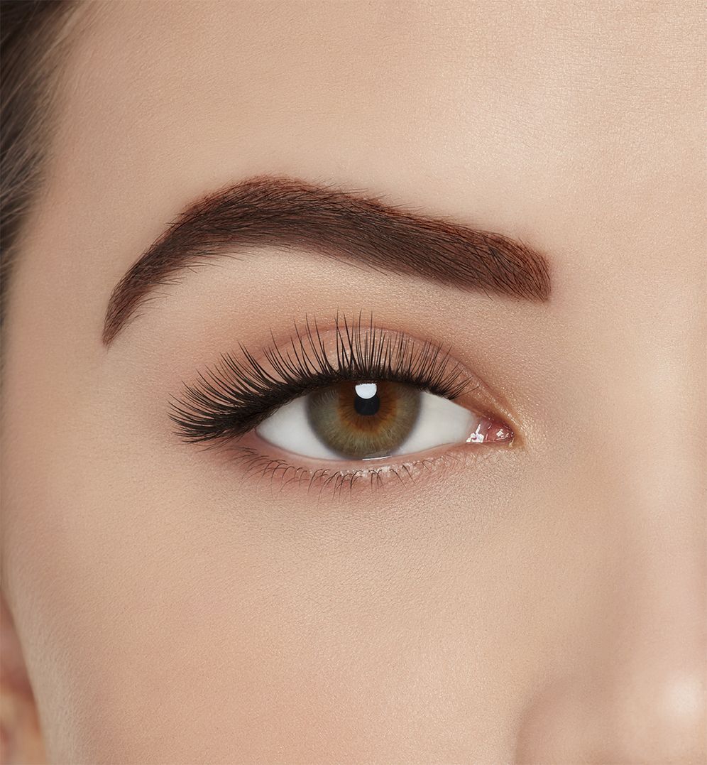 : A model with one eye open wearing Ardell Aqua Lashes 340 upper false lashes to show how they look on the eye